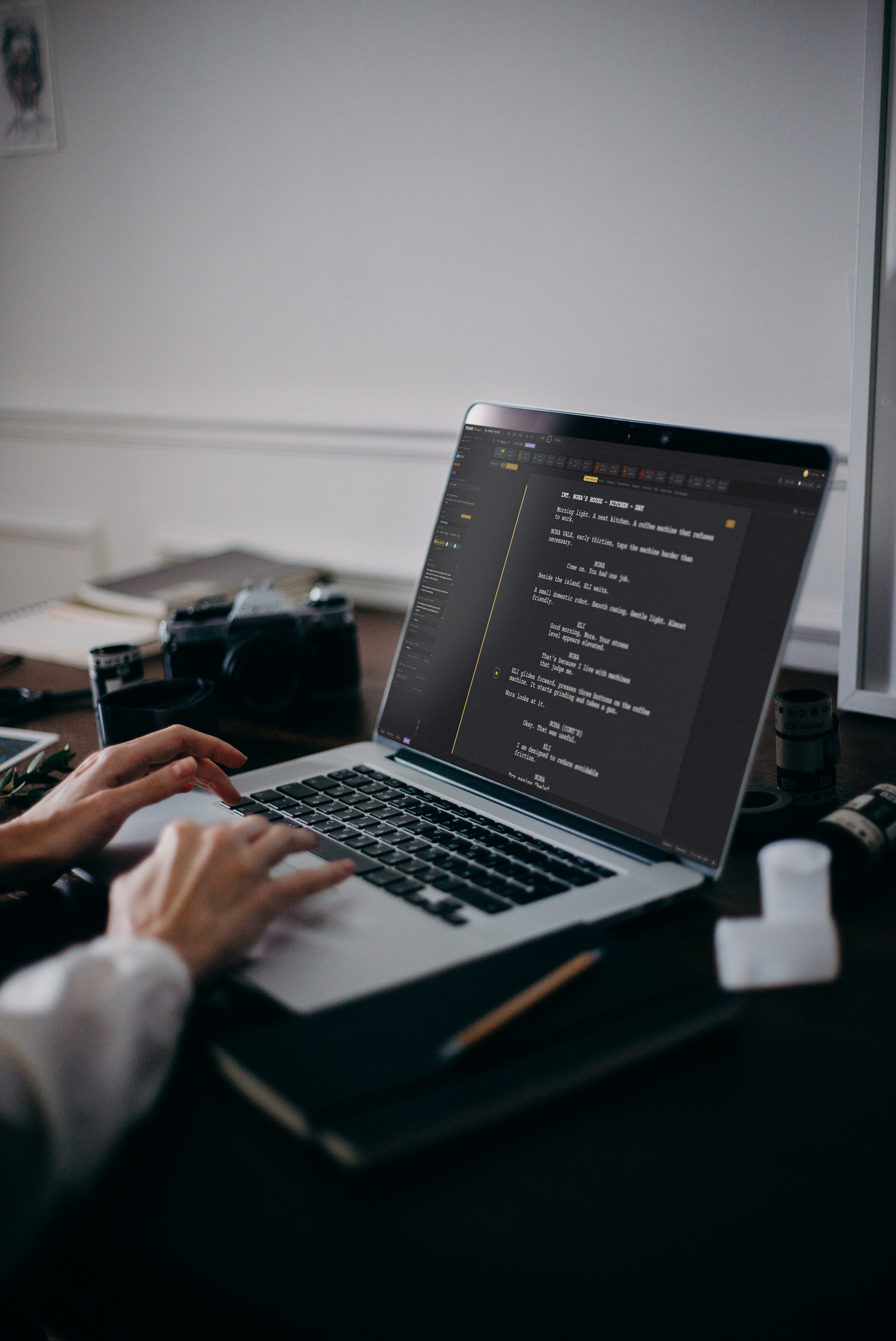 Hands typing on a laptop at a desk